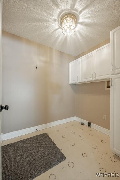 laundry area with cabinets, washer hookup, and a textured ceiling