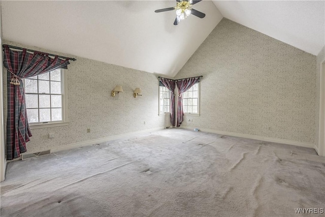 carpeted spare room with ceiling fan and high vaulted ceiling