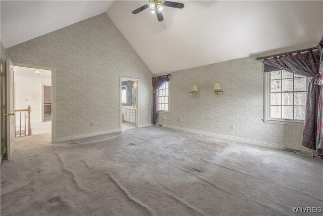 unfurnished living room featuring ceiling fan, light colored carpet, and high vaulted ceiling