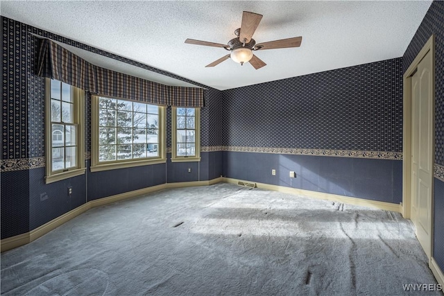 unfurnished room featuring ceiling fan, carpet flooring, and a textured ceiling