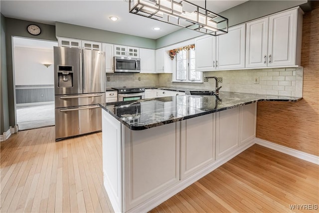 kitchen featuring white cabinetry, sink, hanging light fixtures, kitchen peninsula, and stainless steel appliances