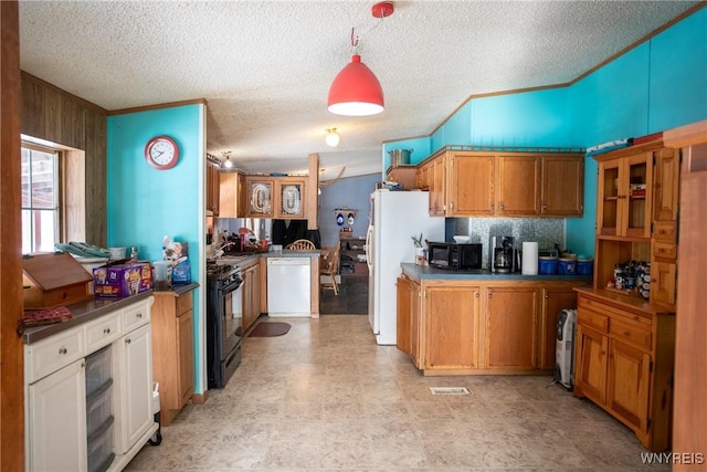 kitchen with ornamental molding, wooden walls, black appliances, and a textured ceiling