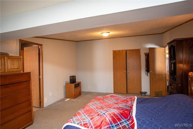 carpeted bedroom featuring ornamental molding and a textured ceiling