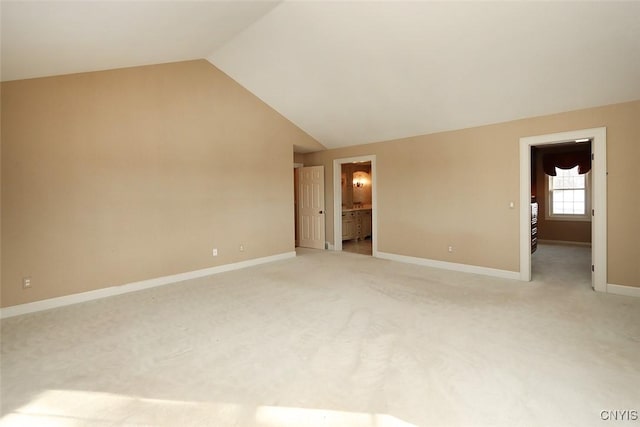 unfurnished room with light carpet and vaulted ceiling