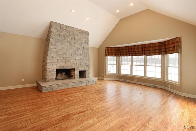 unfurnished living room with a stone fireplace, high vaulted ceiling, and light hardwood / wood-style flooring