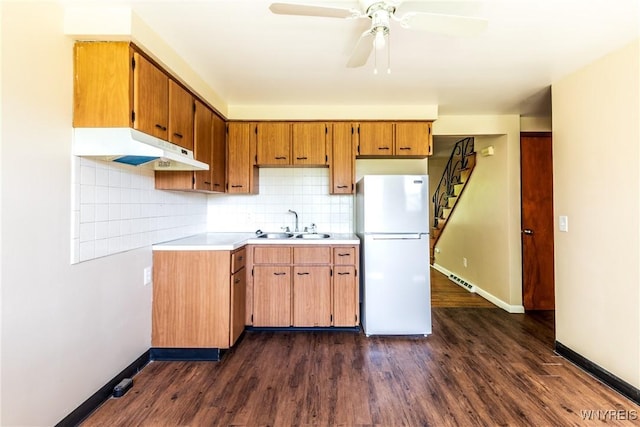 kitchen with sink, backsplash, white refrigerator, ceiling fan, and dark wood-type flooring