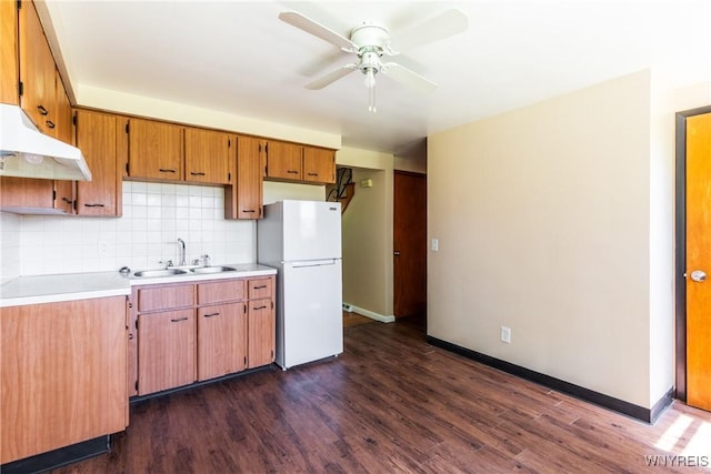 kitchen with sink, dark wood-type flooring, ceiling fan, backsplash, and white fridge