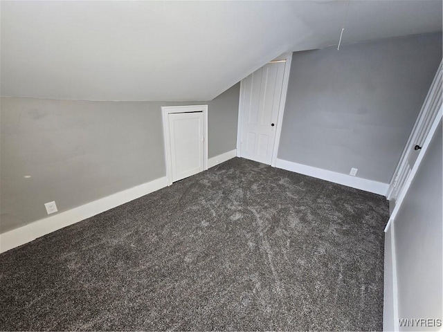 bonus room featuring dark carpet and vaulted ceiling