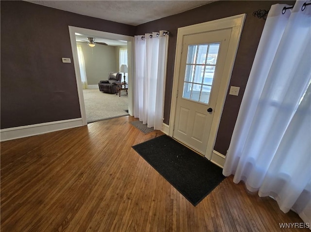 doorway with ceiling fan and hardwood / wood-style floors