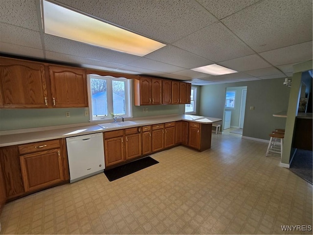 kitchen with dishwasher, sink, a paneled ceiling, and kitchen peninsula