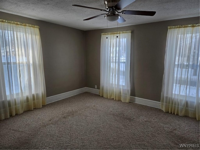 carpeted spare room featuring ceiling fan and a textured ceiling