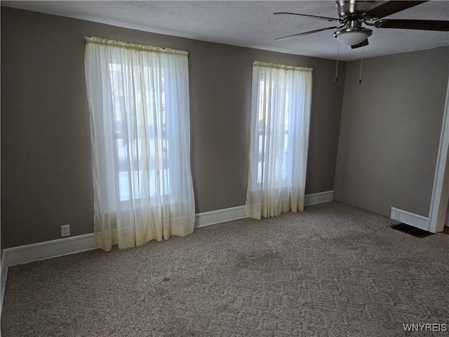 carpeted empty room with ceiling fan and a textured ceiling