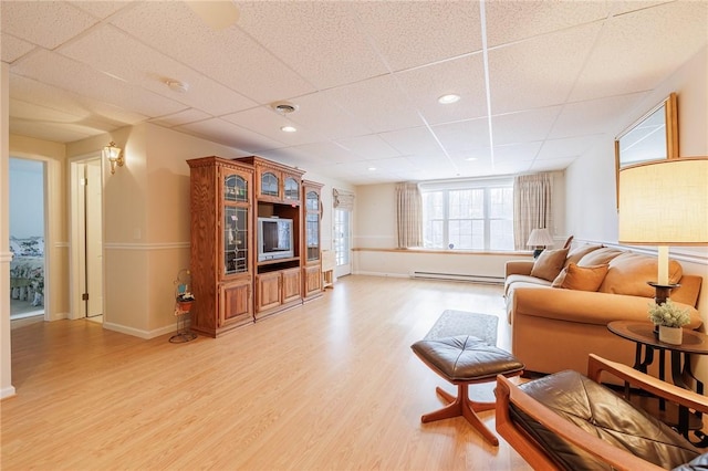 living room featuring a baseboard radiator, a paneled ceiling, and light wood-type flooring