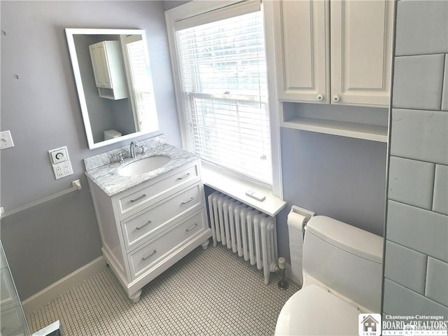 bathroom with radiator heating unit, toilet, and vanity