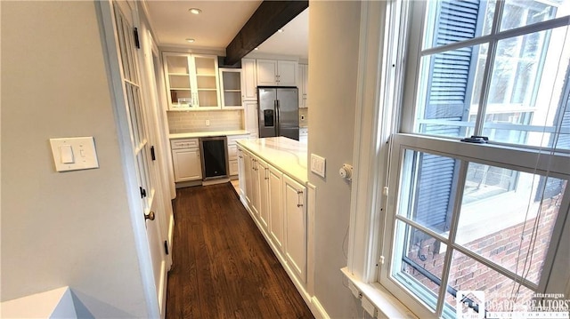 kitchen featuring backsplash, dark hardwood / wood-style flooring, white cabinets, light stone counters, and stainless steel fridge with ice dispenser