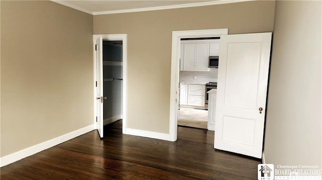 unfurnished bedroom featuring crown molding and dark wood-type flooring