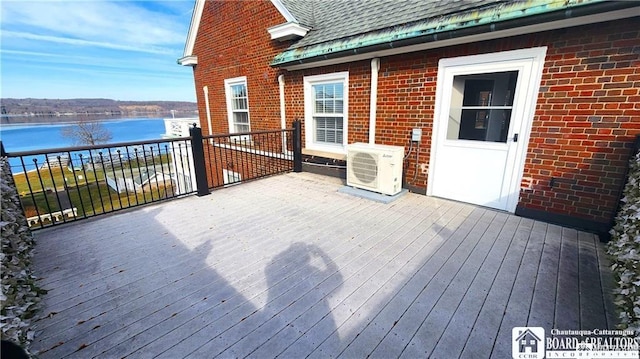 wooden deck featuring a water view and ac unit