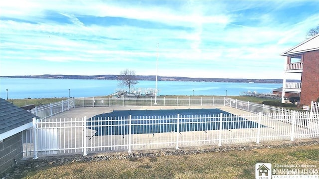 view of pool featuring a water view and a patio