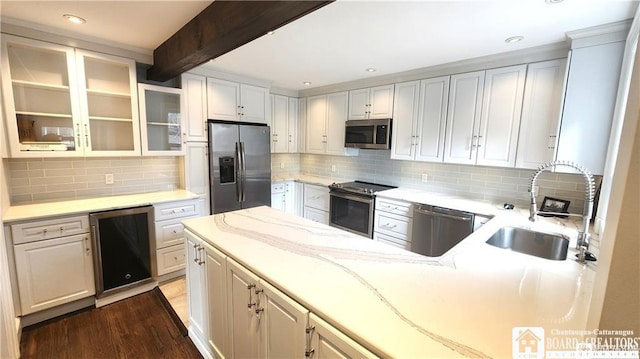 kitchen with sink, light stone counters, appliances with stainless steel finishes, dark hardwood / wood-style floors, and white cabinets