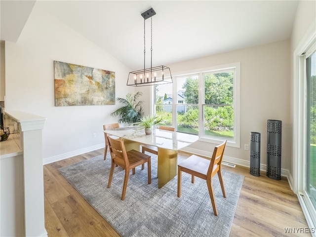 dining space with lofted ceiling and light hardwood / wood-style flooring