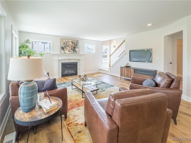 living room featuring a premium fireplace and light hardwood / wood-style floors