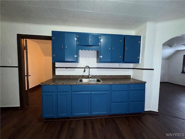 kitchen with sink, dark wood-type flooring, and blue cabinetry