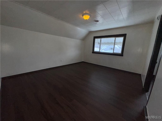 bonus room featuring lofted ceiling and dark hardwood / wood-style flooring