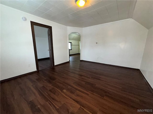 unfurnished room featuring lofted ceiling and dark hardwood / wood-style floors