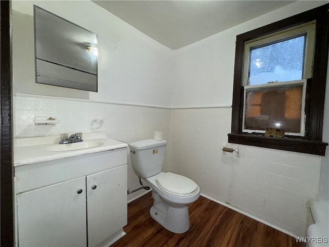 bathroom featuring vanity, hardwood / wood-style floors, tile walls, and toilet