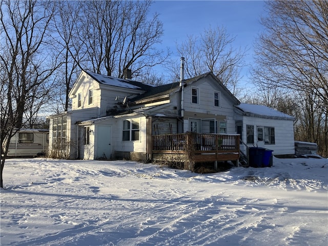 snow covered rear of property featuring a deck