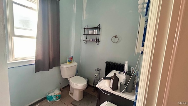 bathroom with toilet and tile patterned flooring