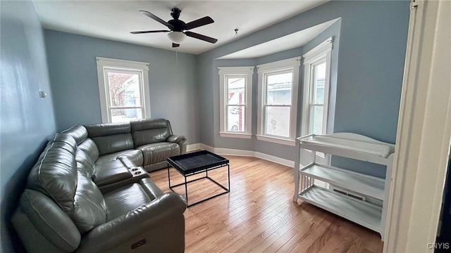 living room featuring ceiling fan and light hardwood / wood-style flooring