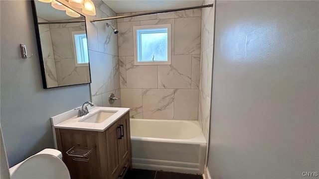 full bathroom featuring tiled shower / bath combo, vanity, and toilet