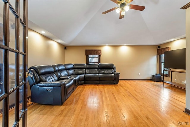 living room featuring vaulted ceiling, a wealth of natural light, and light wood-type flooring