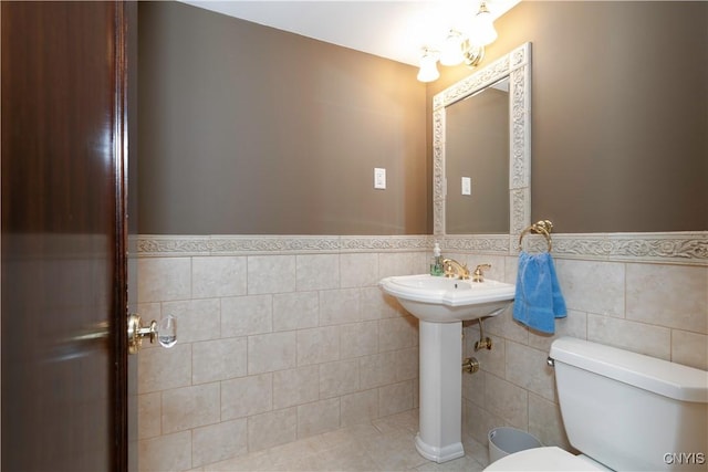 bathroom with tile walls, tile patterned floors, and toilet