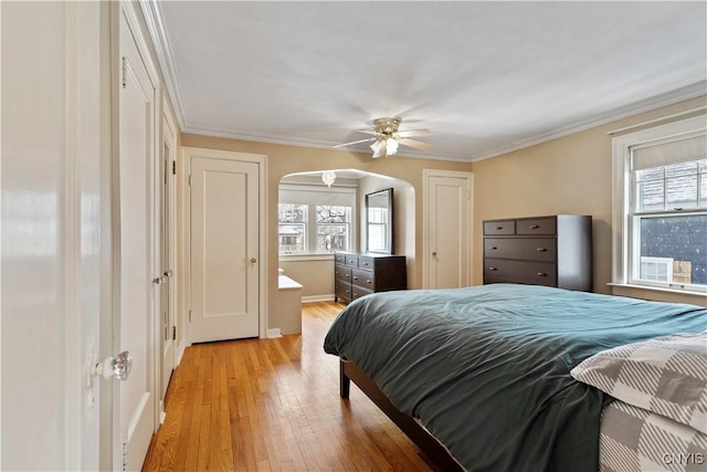 bedroom featuring multiple windows, ornamental molding, light hardwood / wood-style floors, and ceiling fan