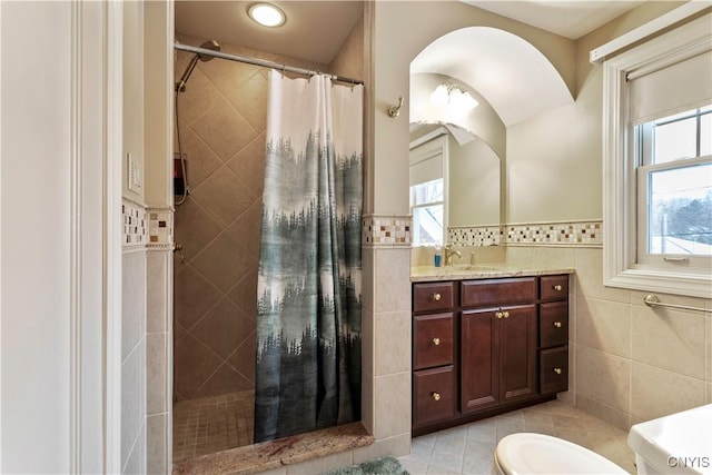 bathroom featuring tile walls, tile patterned flooring, vanity, curtained shower, and toilet