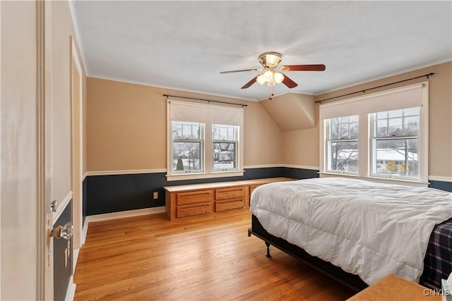 bedroom with multiple windows, ornamental molding, ceiling fan, and light hardwood / wood-style floors