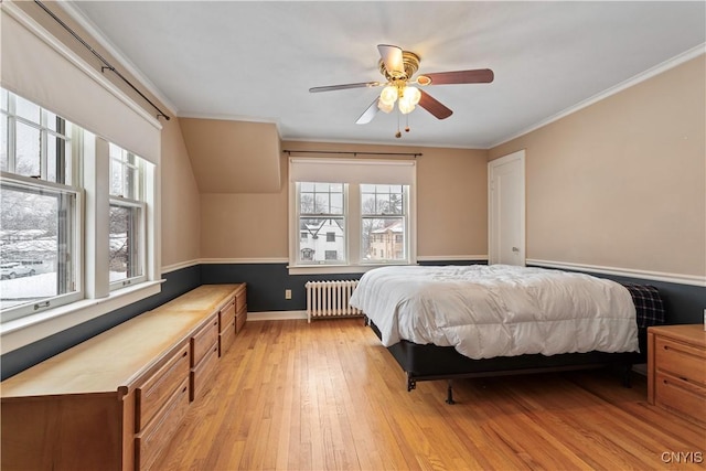 bedroom with crown molding, ceiling fan, radiator heating unit, and light hardwood / wood-style flooring