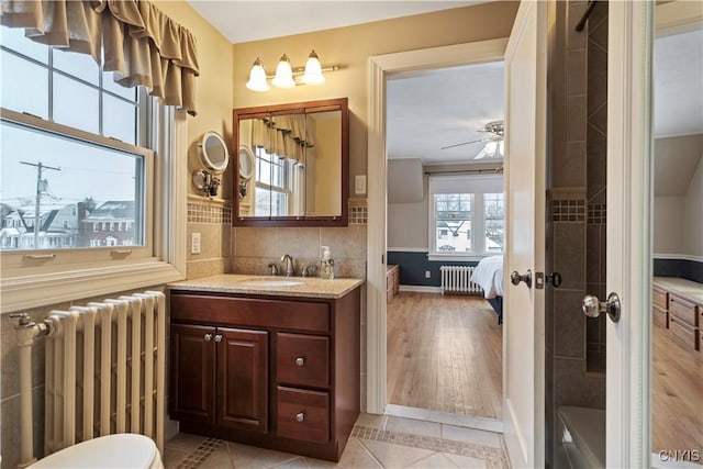 bathroom featuring tile patterned flooring, vanity, radiator, and ceiling fan