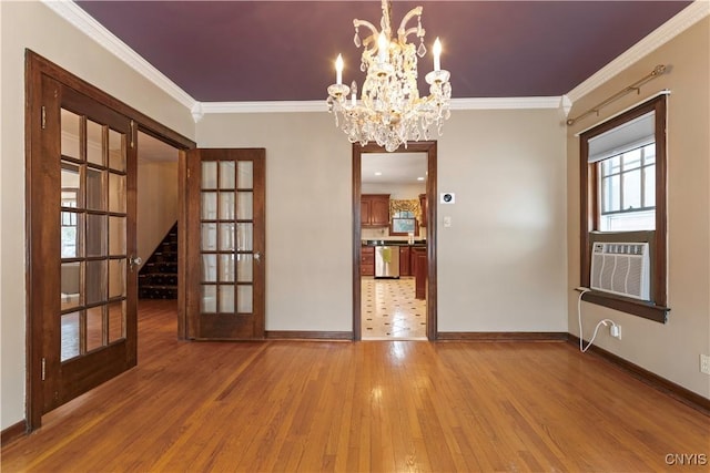 unfurnished dining area featuring cooling unit, hardwood / wood-style floors, crown molding, and french doors