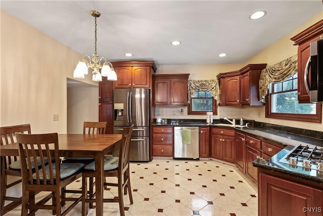 kitchen featuring stainless steel appliances, decorative light fixtures, decorative backsplash, and a wealth of natural light