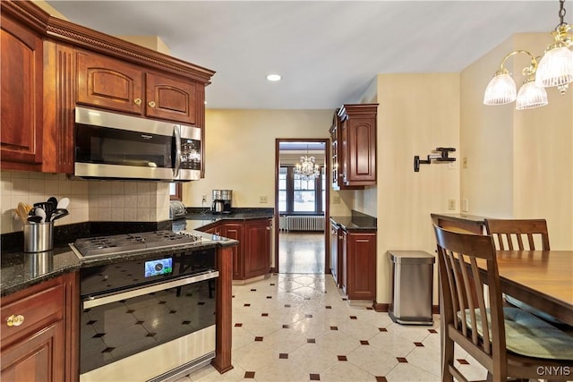 kitchen with radiator, appliances with stainless steel finishes, an inviting chandelier, hanging light fixtures, and decorative backsplash