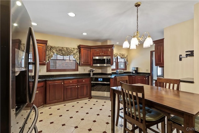 kitchen featuring hanging light fixtures, appliances with stainless steel finishes, a notable chandelier, and decorative backsplash