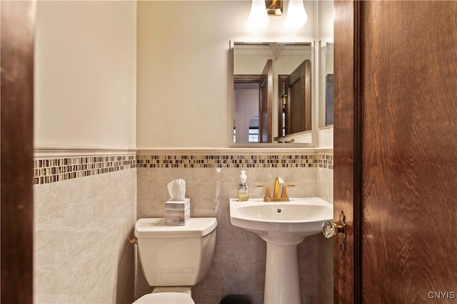 bathroom with toilet and tile walls