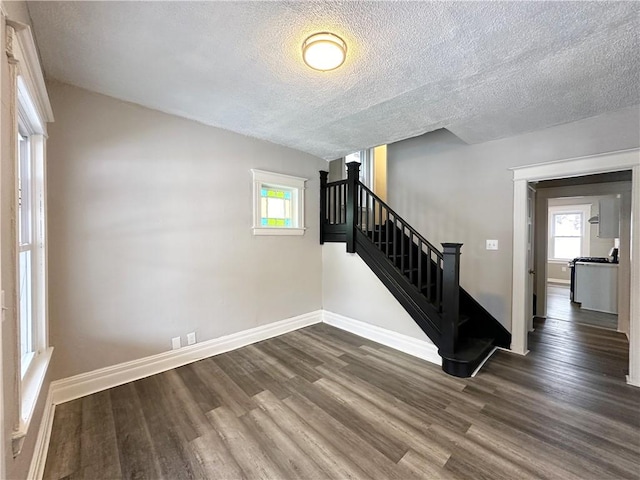 stairway with hardwood / wood-style floors and a textured ceiling