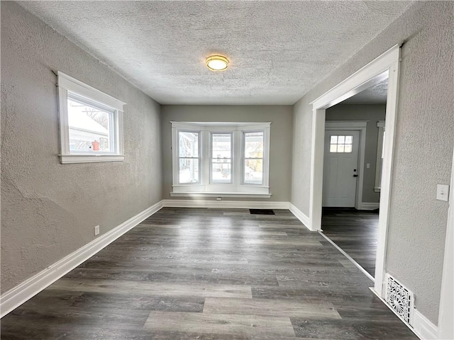 interior space featuring dark wood-type flooring and a textured ceiling