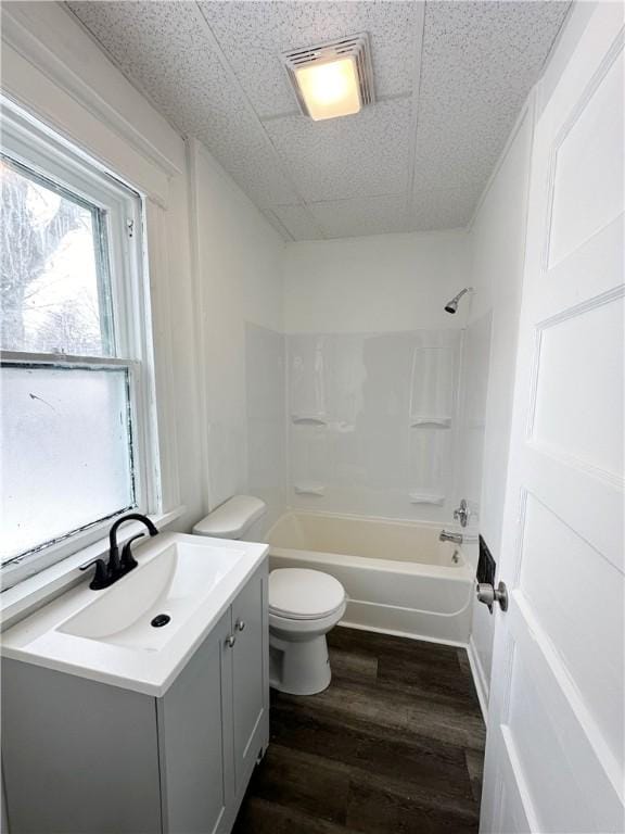 full bathroom with toilet, a paneled ceiling, tub / shower combination, vanity, and hardwood / wood-style flooring