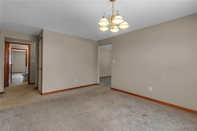 carpeted spare room featuring an inviting chandelier