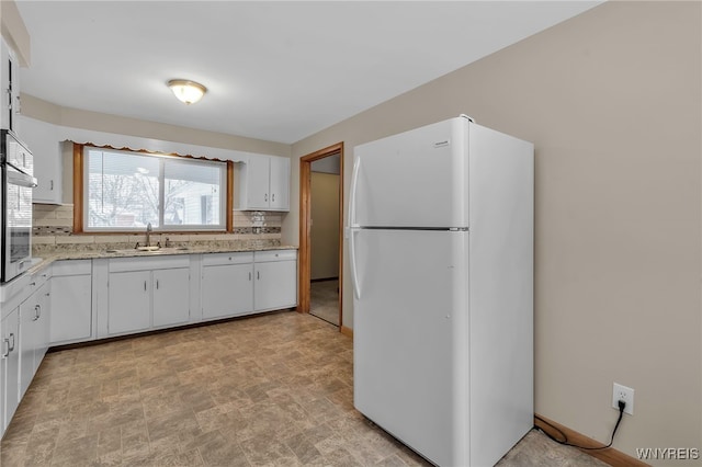 kitchen with backsplash, white appliances, sink, and white cabinets